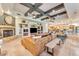 Large living room with coffered ceiling, fireplace, and entertainment center with views into the kitchen at 11505 E Cochise Dr, Scottsdale, AZ 85259