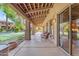 Covered patio with stylish seating with a view of the beautiful grass, landscaping, and putting green at 11505 E Cochise Dr, Scottsdale, AZ 85259