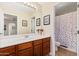 Bright bathroom with a wood vanity and modern light fixture, with a separate shower and toilet room at 11866 N 143Rd Ave, Surprise, AZ 85379