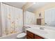 Bathroom featuring a tub and shower with floral curtain, a wooden vanity, and neutral paint at 11866 N 143Rd Ave, Surprise, AZ 85379