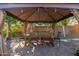 Charming gazebo with string lights and rustic wood furniture perfect for dining and entertaining at 11866 N 143Rd Ave, Surprise, AZ 85379