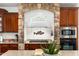 Elegant kitchen details include stone archway above the stovetop, detailed cabinetry, and modern appliances at 11866 N 143Rd Ave, Surprise, AZ 85379