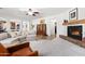 Bright open-concept living room with a fireplace and comfortable seating with an open access to the kitchen at 11866 N 143Rd Ave, Surprise, AZ 85379