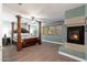 Spacious main bedroom features a four-poster bed, fireplace, and wood flooring at 11866 N 143Rd Ave, Surprise, AZ 85379