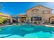 Spacious backyard pool with a Baja step, sun umbrellas, and outdoor seating areas at 11866 N 143Rd Ave, Surprise, AZ 85379