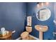 Charming powder room features blue walls, unique sink, and decorative mirror at 11866 N 143Rd Ave, Surprise, AZ 85379