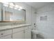 Bright bathroom featuring a granite vanity top, white cabinets, and a tiled shower-tub combination with updated fixtures at 1225 E San Angelo Ave, Gilbert, AZ 85234