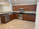 Well-lit kitchen featuring stainless steel appliances, wooden cabinets, and tile flooring at 12848 W Desert Mirage Dr, Peoria, AZ 85383