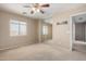 Bedroom with neutral carpet, ceiling fan, a window, and mirrored closet doors at 1370 S 228Th Ln, Buckeye, AZ 85326