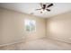 Bright bedroom featuring neutral carpet, ceiling fan, and a window offering natural light at 1370 S 228Th Ln, Buckeye, AZ 85326