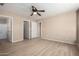 Spacious bedroom with wood flooring, a ceiling fan, and multiple doorways leading to other rooms at 1370 S 228Th Ln, Buckeye, AZ 85326