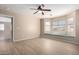 Light-filled bedroom featuring wood flooring, a ceiling fan, and a comfortable window seat at 1370 S 228Th Ln, Buckeye, AZ 85326