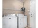 Laundry room with white washer and dryer, storage shelves, and tile flooring at 1370 S 228Th Ln, Buckeye, AZ 85326