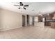 Open-concept living space featuring tile floors, ceiling fan, and seamless flow into the kitchen area at 1370 S 228Th Ln, Buckeye, AZ 85326