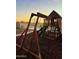 Backyard with a play structure, grass, paved walkway, and white fence at 1370 S 228Th Ln, Buckeye, AZ 85326