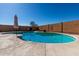 Backyard pool surrounded by brick walls and concrete patio at 1370 S 228Th Ln, Buckeye, AZ 85326