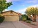 Tan house with tile roof, two-car garage, and desert landscaping at 13830 W Fargo Dr, Surprise, AZ 85374