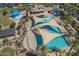 Aerial view of community pools with lounge chairs and shaded areas for relaxation at 1437 W Smoke Tree Ave, San Tan Valley, AZ 85140