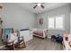 Bedroom with wood-look tile, ceiling fan and decorative objects including baseball themed decor at 1437 W Smoke Tree Ave, San Tan Valley, AZ 85140