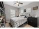 Comfortable bedroom with a ceiling fan, closet, wood-look tile flooring, and modern shutters at 1437 W Smoke Tree Ave, San Tan Valley, AZ 85140