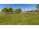 Expansive green community park area with walking paths, trees, and a playground for outdoor enjoyment at 1437 W Smoke Tree Ave, San Tan Valley, AZ 85140