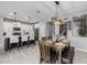 Dining area has a modern light fixture, seating for six, with access to the kitchen and other living spaces at 1437 W Smoke Tree Ave, San Tan Valley, AZ 85140
