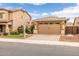 Charming home exterior with a two-car garage, desert landscaping, and a well-maintained lawn at 1437 W Smoke Tree Ave, San Tan Valley, AZ 85140