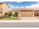 Charming home exterior with a two-car garage, desert landscaping, and a well-maintained lawn at 1437 W Smoke Tree Ave, San Tan Valley, AZ 85140