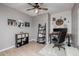 Home office includes light colored wood-look tile, ceiling fan, desk and white shiplap accent wall at 1437 W Smoke Tree Ave, San Tan Valley, AZ 85140