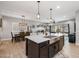 Open concept kitchen featuring a stainless steel sink, quartz countertop, bar seating and adjacent living spaces at 1437 W Smoke Tree Ave, San Tan Valley, AZ 85140