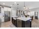 Stylish kitchen island features a stainless steel sink, modern faucet, and an eating bar with pendant lighting at 1437 W Smoke Tree Ave, San Tan Valley, AZ 85140