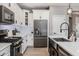 Well-equipped kitchen featuring white cabinetry, stainless steel appliances, a subway tile backsplash, and a modern faucet at 1437 W Smoke Tree Ave, San Tan Valley, AZ 85140