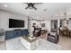 Inviting living room boasts a ceiling fan, cozy seating, and an open layout flowing into the modern kitchen at 1437 W Smoke Tree Ave, San Tan Valley, AZ 85140