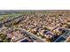 Expansive aerial view of a residential community featuring numerous homes with solar panels near a lush green golf course at 1808 E Crocus Ave, Queen Creek, AZ 85140