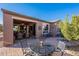 Inviting backyard featuring a brick patio, covered area and sliding glass door at 1808 E Crocus Ave, Queen Creek, AZ 85140