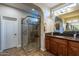 Bathroom featuring a walk-in shower with glass surround, and granite-topped vanity with wood cabinetry at 1808 E Crocus Ave, Queen Creek, AZ 85140