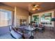 Comfortable covered patio featuring an outdoor fireplace, ceiling fan, and ample seating area at 1808 E Crocus Ave, Queen Creek, AZ 85140