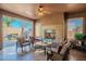 Comfortable covered patio featuring an outdoor fireplace, ceiling fan, and ample seating area at 1808 E Crocus Ave, Queen Creek, AZ 85140