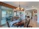 Elegant dining room with chandelier, large windows and dining table for six at 1808 E Crocus Ave, Queen Creek, AZ 85140