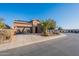 Charming single-story home with a two-car garage, desert landscaping, and solar panels on a sunny day at 1808 E Crocus Ave, Queen Creek, AZ 85140