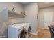 Laundry room featuring white appliances and storage shelf for convenience at 1808 E Crocus Ave, Queen Creek, AZ 85140