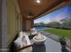 Inviting covered patio with a fire pit and a view of the pool and green lawn at dusk at 18509 W Galveston St, Goodyear, AZ 85338