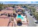 Aerial view of a community pool area, featuring a covered seating area, lounge chairs, and lush landscaping at 1905 E University Dr # 216, Tempe, AZ 85288