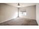 Bedroom featuring neutral carpet, ceiling fan, and large window at 1905 E University Dr # 216, Tempe, AZ 85288