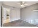 Bedroom with ceiling fan, neutral carpet, closet, and access to the bathroom at 1905 E University Dr # 216, Tempe, AZ 85288