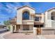Exterior view of a townhome, showcasing stucco architecture, a private balcony, and a well-kept walkway at 1905 E University Dr # 216, Tempe, AZ 85288