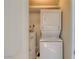 A compact laundry space with a stacked washer and dryer, and a hot water tank at 1905 E University Dr # 216, Tempe, AZ 85288