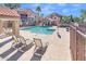 Community pool with lounge chairs, clear blue water, and surrounding landscaping within a gated area at 1905 E University Dr # 216, Tempe, AZ 85288