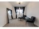 Cozy bedroom features two black lounge chairs, full length mirror and window with black sheer curtains at 34395 N Cherrystone Dr, San Tan Valley, AZ 85144