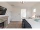 Comfortable bedroom with a fireplace, TV, black metal bed frame, soft carpet, and bright natural light at 34395 N Cherrystone Dr, San Tan Valley, AZ 85144
